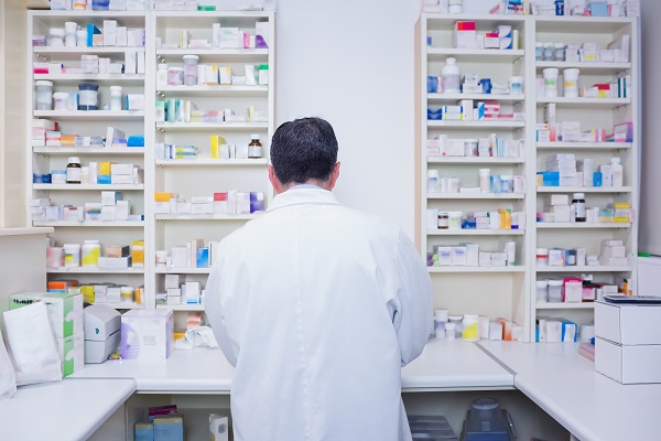 Rear view of a pharmacist working in lab coats in the pharmacy